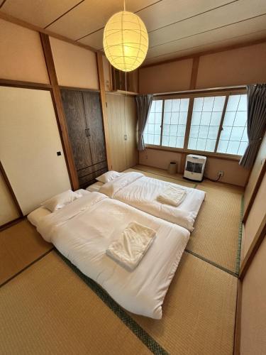 a large bed in a room with windows at AOMORI LOVERS Minatomachi Base in Aomori