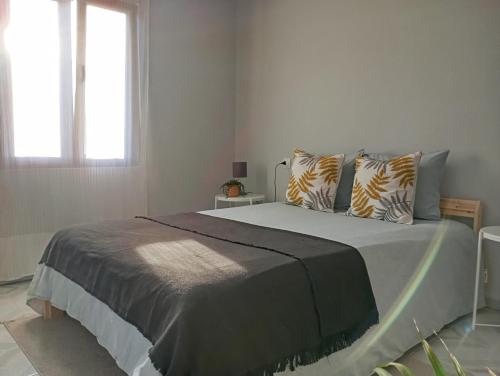 a white bedroom with a large bed with pillows at Estación celorio in Celorio