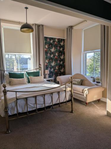 a bedroom with a bed and a couch and windows at The King's Head, Lanchester in Durham