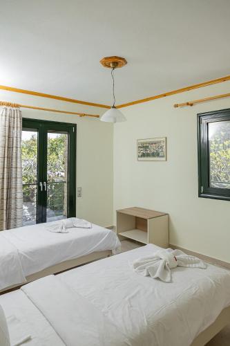 two white beds in a room with a window at Zeusplace Crown Platamon in Platamonas