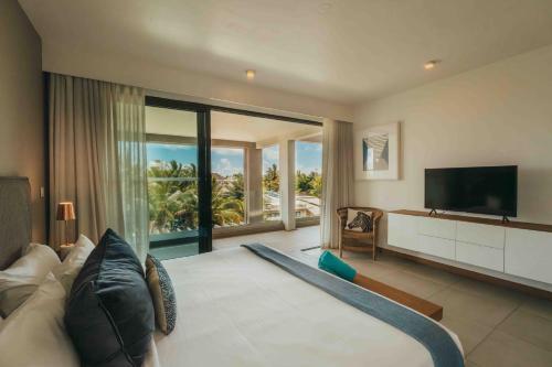 a living room with a couch and a television at Mythic Suites & Villas by MJ Holidays in Grande Gaube
