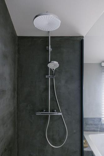 a bathroom with a shower with a shower head at La Maison des Champs in Ciney