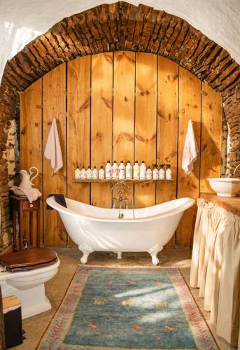 a bath tub in a bathroom with a wooden wall at Tôlluste Villa in Tõlluste