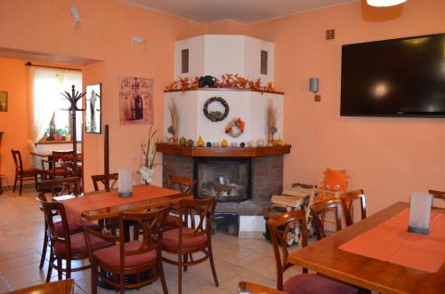 a restaurant with tables and a fireplace and a tv at Hotel u Kapra in Lázně Bělohrad