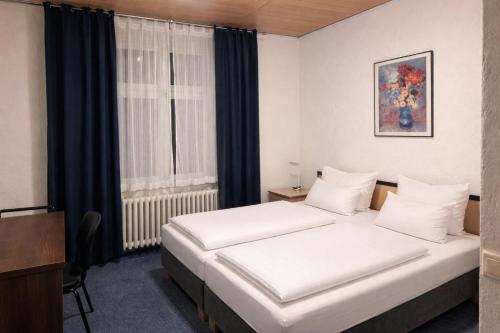 a bedroom with two beds and a window at HELENA Hotel & Restaurant in Mirow