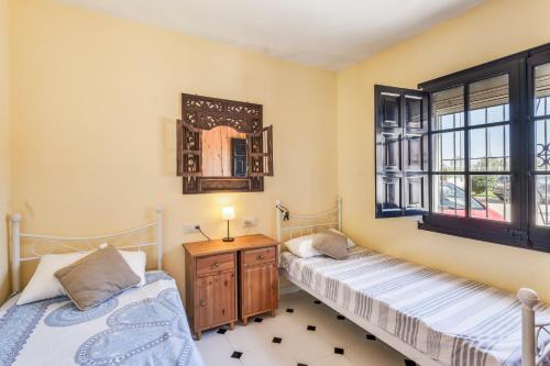 two beds in a room with a mirror and a window at Ducado B104 in Pals