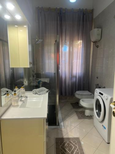 a bathroom with a sink and a washing machine at Galliu'S home in Selargius