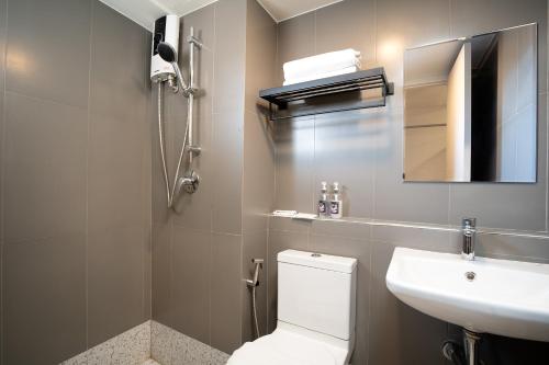 a bathroom with a toilet and a sink and a mirror at Synsiri Lat Phrao 83 in Ban Zong Katiam