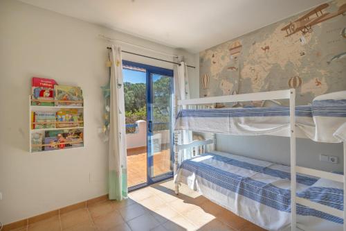 a bedroom with two bunk beds and a sliding glass door at Bosc in Pals
