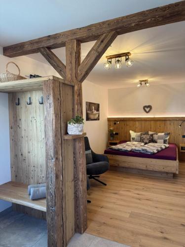 a bedroom with a bed in a room with wooden beams at Winkelfeldhof in Eglfing