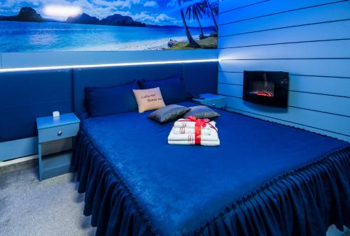 a blue bed in a room with a fireplace at Sobe i Apartmani Vila Modex in Paraćin