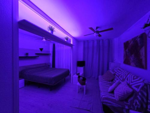 a purple room with a bed and a couch at Apartamento en Mar Blau Calella in Calella