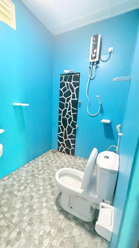 a bathroom with a toilet with a phone on the wall at Hotel Angel Inn Beach in Trincomalee