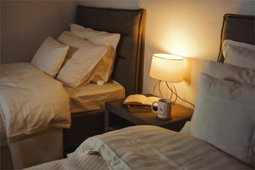 a room with two beds and a lamp and a phone at BB Residence Sololaki in Tbilisi City