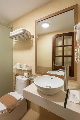 a bathroom with a sink and a toilet and a mirror at Splendid Star Suite Hotel in Hanoi