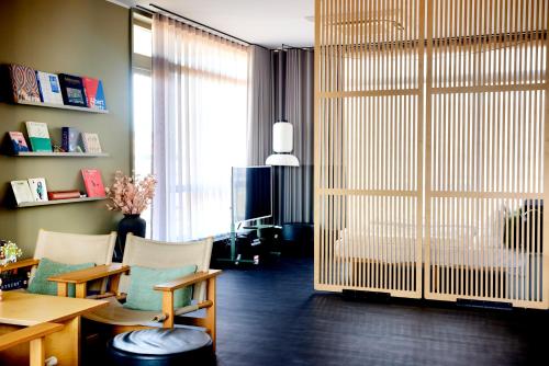 ein Wohnzimmer mit Tisch und Stühlen und einem großen Fenster in der Unterkunft CPH Hotel in Kopenhagen