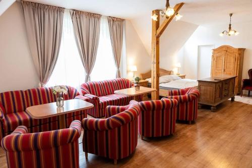 a hotel room with red striped chairs and a bed at Tavba apartment in Česká Lípa