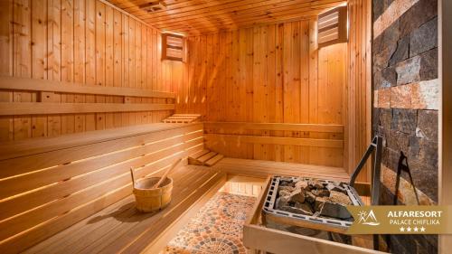 a wooden sauna with a tub in the middle at Alfaresort Palace Chiflika in Chiflik