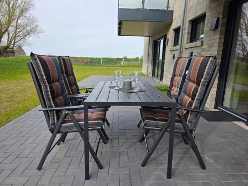 a wooden table and chairs on a patio at Ferienwohnung Möwentöne in Bensersiel