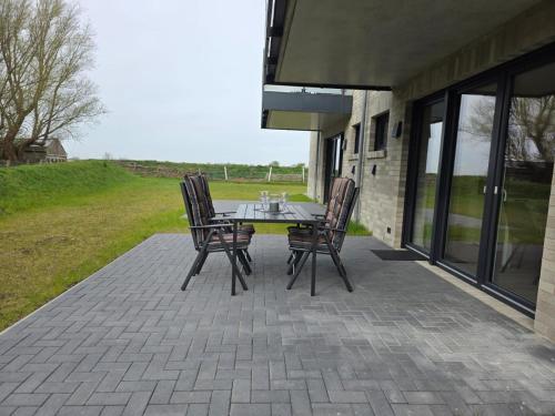 a patio with a table and chairs on a porch at Ferienwohnung Möwentöne in Bensersiel