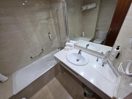 a bathroom with a sink and a shower and a toilet at Hotel Saylu in Granada