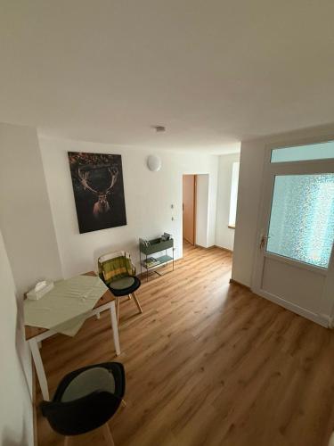 an empty living room with a table and chairs at Ferienwohnung Waidmannsheil in Amtsberg