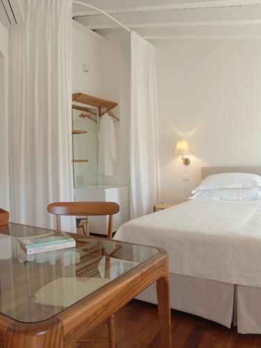 a hotel room with a bed and a glass table at La Sosta di Ottone III in Levanto