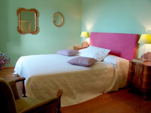 a bedroom with a large bed with a pink headboard at La Sosta di Ottone III in Levanto
