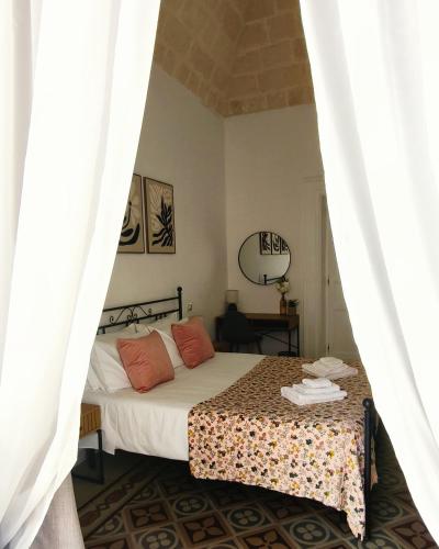 a bedroom with a bed with white sheets and orange pillows at Dimora Tarantina in Taranto