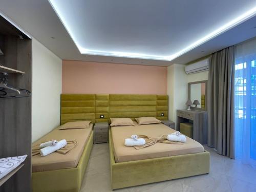 a room with two beds with towels on them at Elko Apartments & Rooms in Golem