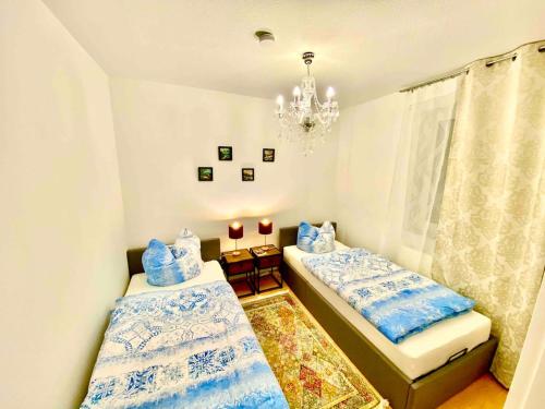 a bedroom with two beds and a chandelier at Weimar Cityappartement in Weimar