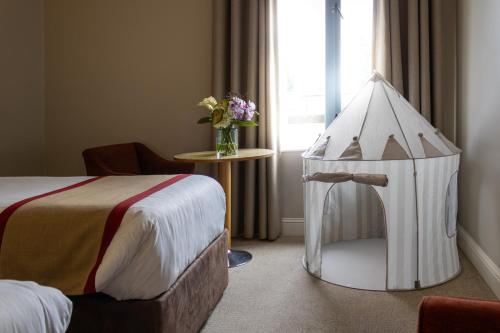 a room with a bed and a white tent next to a window at Great National South Court Hotel in Limerick
