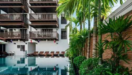 a view of the swimming pool of a hotel with palm trees at El Barrio Lanna in Chiang Mai