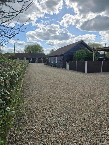 a gravel driveway in front of a house at Oak Cottage with private log fired hot tub in Maidstone