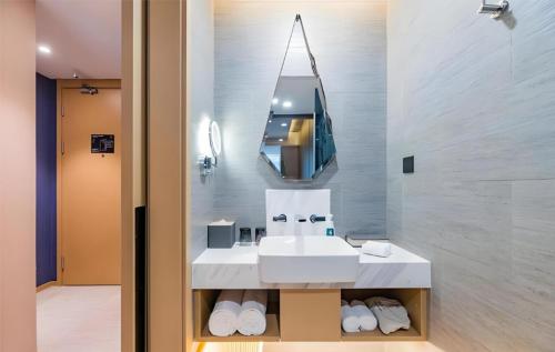 a bathroom with a white sink and a mirror at 北京三里屯天安门亚朵酒店 in Beijing