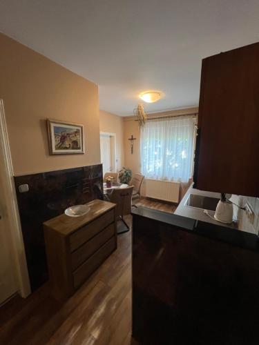 a kitchen with a counter top and a living room at Bedi Apartmanház in Nagykanizsa