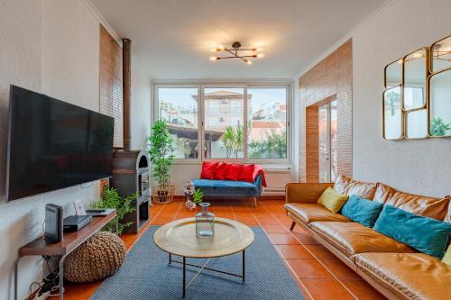 a living room with a couch and a tv at Setúbal Oasis House, By Home Match in Setúbal