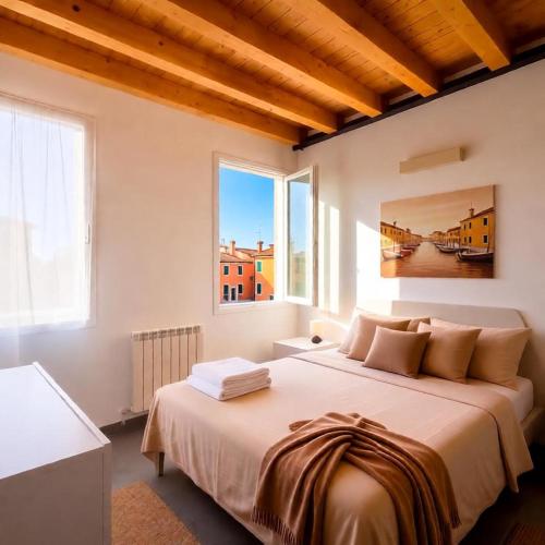 a bedroom with a large bed with a large window at Suite Laguna Sunset in Chioggia