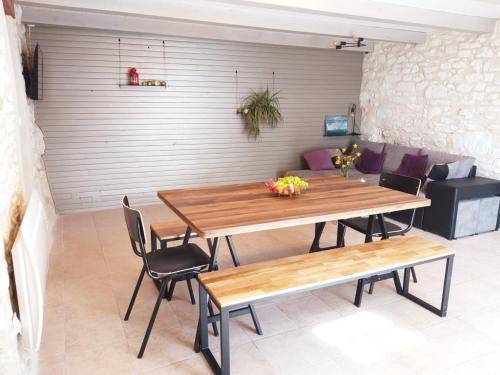 a wooden table and chairs in a living room at La Borieta in Labastide-de-Penne