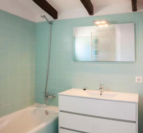 a bathroom with a sink and a tub and a mirror at San Colomban in Sant Lluis