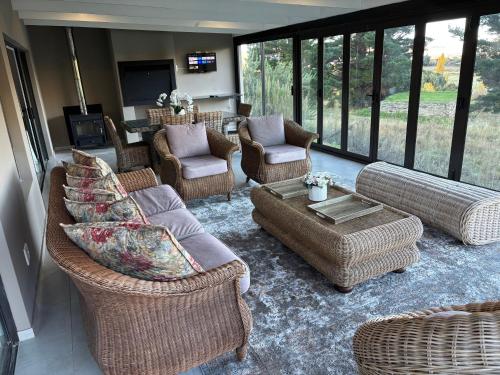a living room with wicker chairs and couches at 127 Clarens Golf Villa in Clarens