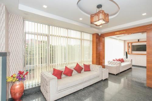a living room with two couches and a large window at Hotel O Royal Stay in Bangalore