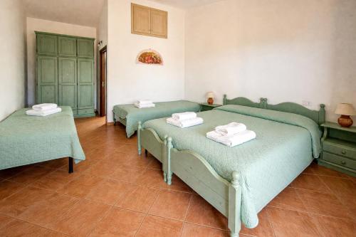 three green beds in a room with tile floors at Tegghja Country Suites in Rena Majore