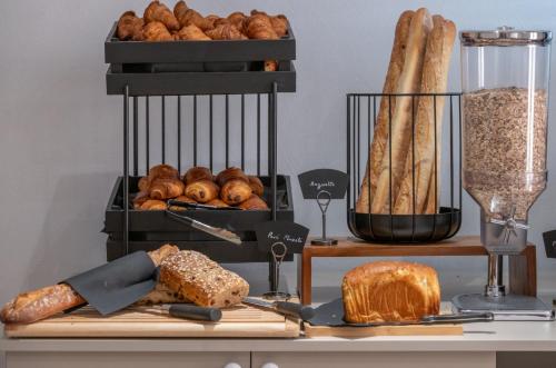 a table with bread and loaves of bread at The Originals city, Hôtel Harys in Vichy