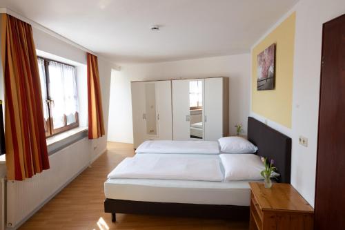 a bedroom with two beds and a mirror at Gästehaus Willanzheim in Willanzheim