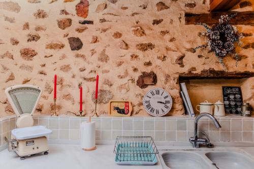 a kitchen with a sink and a clock on the wall at Casona del Tambor in Calatañazor