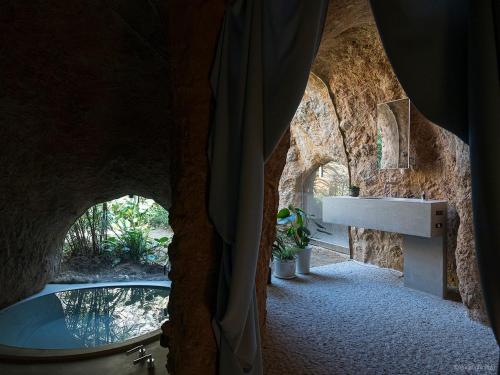 ein Badezimmer mit Badewanne und Waschbecken in einer Höhle in der Unterkunft maison owl in Ube