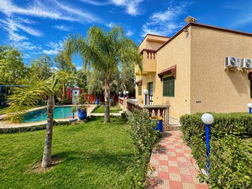 ein Haus mit einem Garten mit einem Swimmingpool in der Unterkunft Villa Eden Atlas Ourika in Sbiti