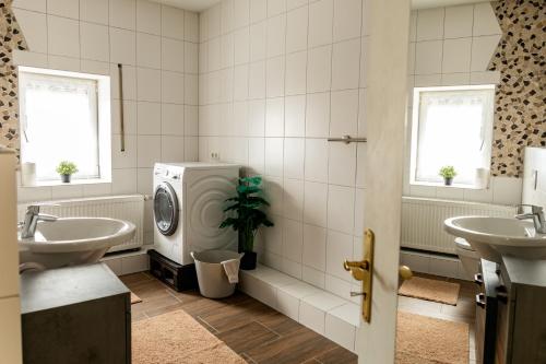 a bathroom with two sinks and a washing machine at Ferienwohnung Otto in Pegnitz