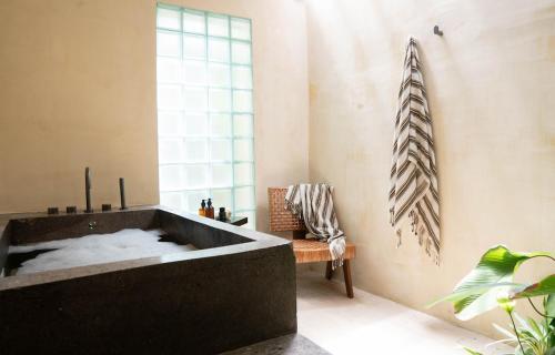 a black bath tub in a room with a chair at Casa Kalma in General Luna